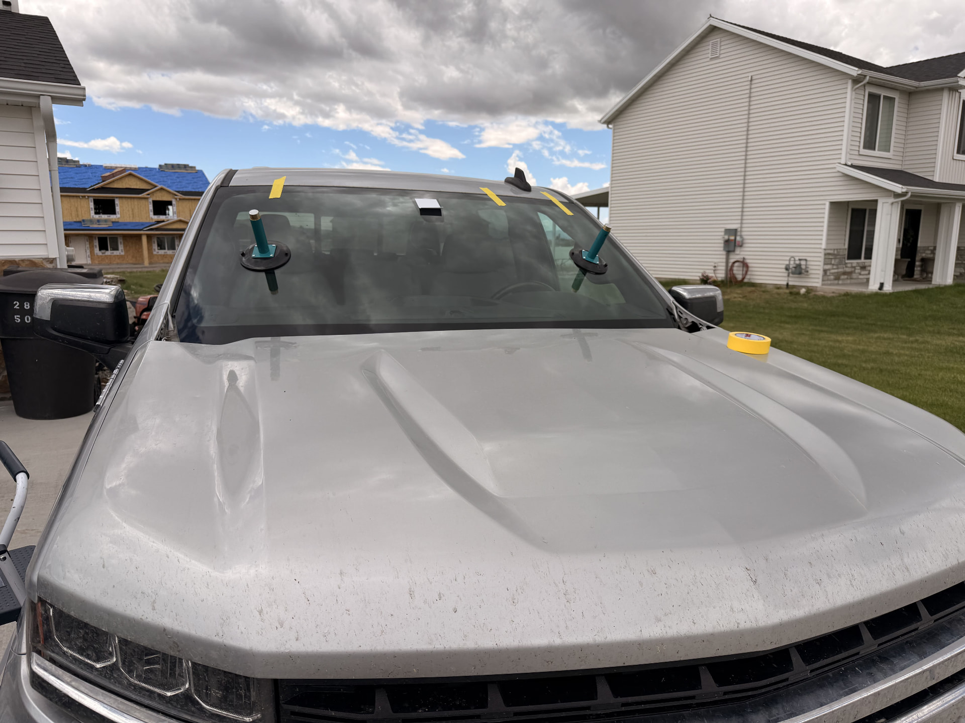 Windshield suction tools in active use during a mobile replacement on a pickup truck