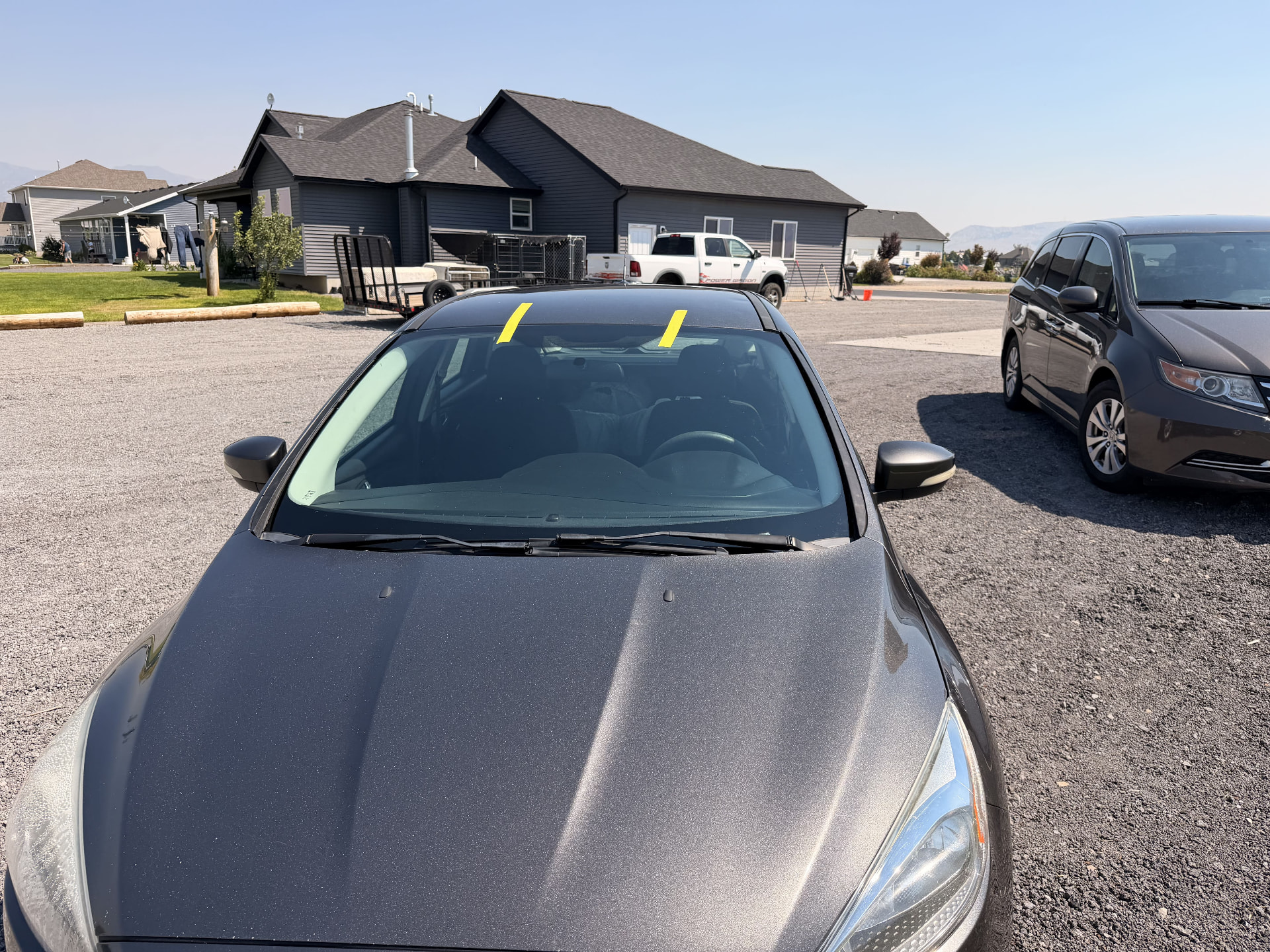 Sedan windshield replaced on-site in a residential driveway