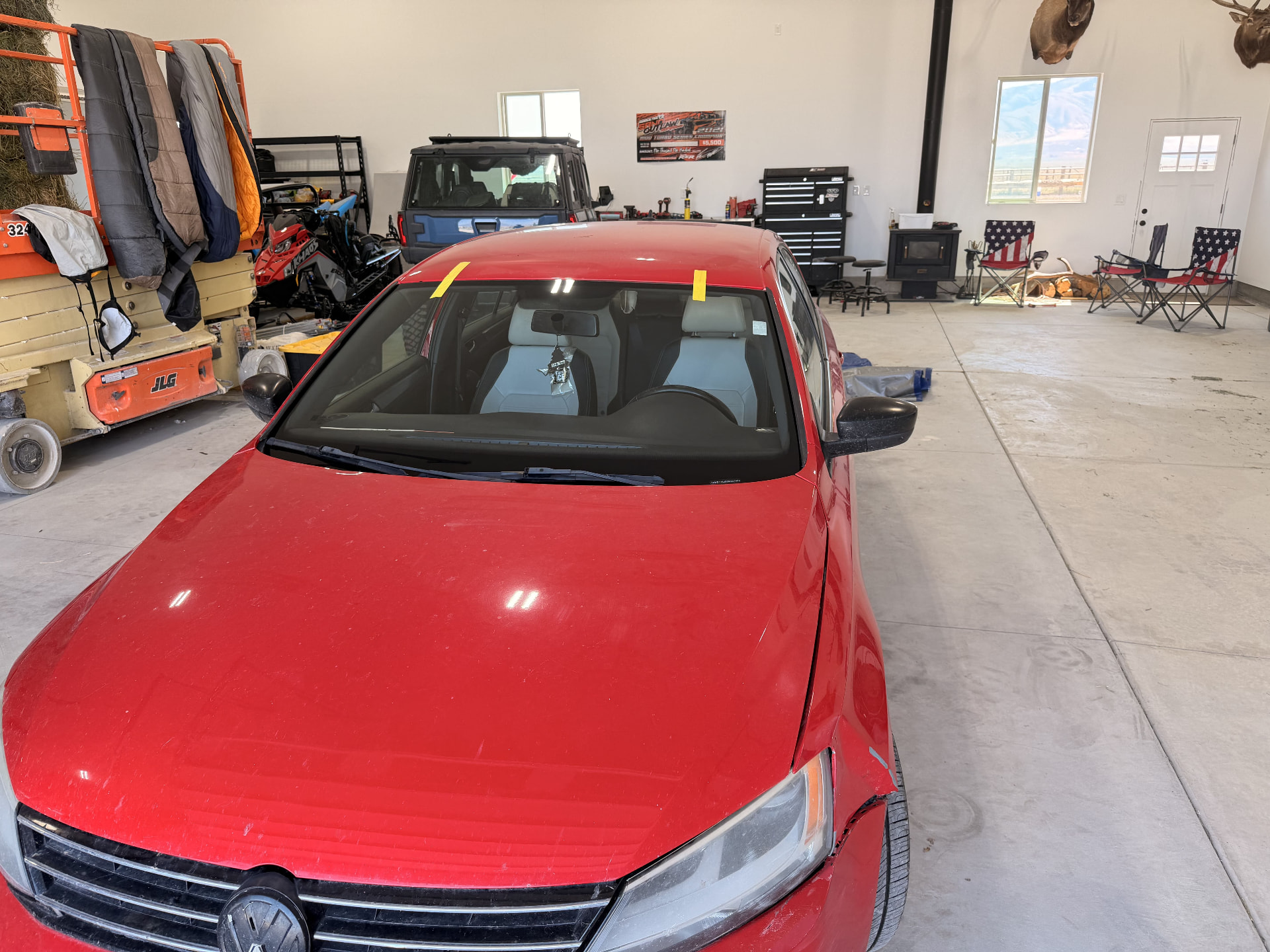 Red Volkswagen sedan windshield installed during a mobile service visit