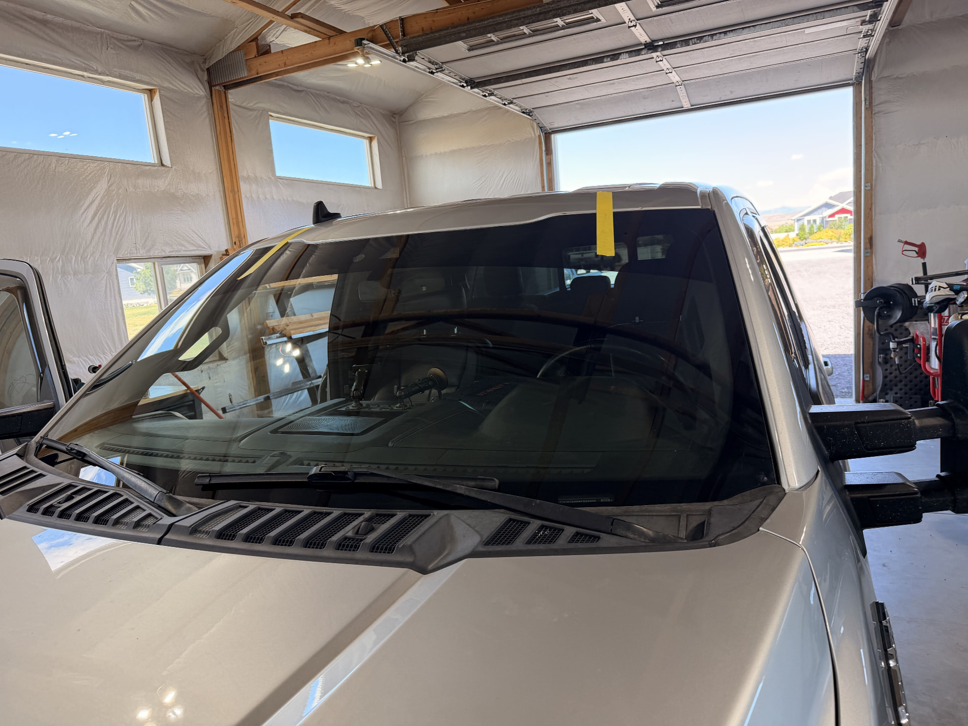 Silver pickup truck windshield installed on-site with retention tape in place